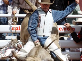 Jody Turner rides a bull and scores 84.5 in the bull riding event at the Calgary Stampede, July 12.