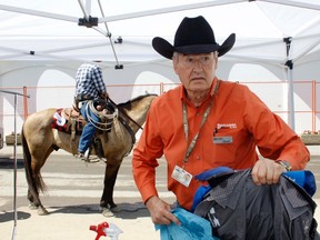 Dave Barker, owner of Drycleaning by Dave, sorts clothes from cowboys and cowgirls at the Calgary Stampede, July 7. They’ve been the official drycleaner there for 10 years.