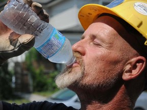 George Lavoie takes a water break during construction on Boswell Street in Belleville. Workers at the site left the job early both Tuesday and Wednesday due to heat and humidity. W. BRICE MCVICAR/QMI Agency/ The Intelligencer