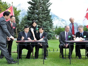 Director of the Mt. Huangshan Scenic Area Administrative Committee Jiwei Xu and minister of the State Forestry Administration Zhao Shucong sign the twinning agreement across from vice president of Western Canada Jeff Anderson and Banff National Park superintendent Dave McDonough on Sunday, July 14, 2013. Banff National Park now has a sister park — China's Huangshan National Forest Park. CORRIE DIMANNO/CRAG & CANYON/QMI AGENCY