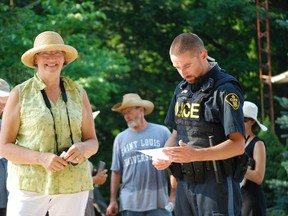 Suzanne Andrews of Port Ryerse helped organize a wind turbine protest north of the village Wednesday evening that attracted about 40 picketers. An officer with the Norfolk OPP dropped by to ensure the group was conducting itself in a safe manner and staying out of the way of traffic. (MONTE SONNENBERG Simcoe Reformer)