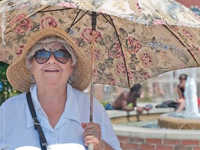 Janet Bond of Brantford uses an umbrella to keep the sun off while strolling downtown on Wednesday. (Brian Thompson, The Expositor)