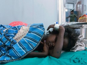 A sick child rests at a hospital after consuming contaminated school meals in the eastern Indian city of Patna July 17, 2013. At least 22 children died and dozens were taken to hospital with apparent food poisoning after eating a meal provided for free at their school in the Indian state of Bihar, officials said on Wednesday, sparking violent protests. (REUTERS/Stringer)