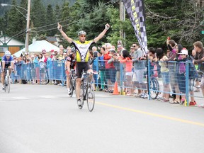 Colin Croston of the Rundle Mountain Cycling Club raises his hands in victory after winning the criterium race in Category 3 men's on Saturday, July 13, 2013 in downtown Canmore. Croston went on to win all three of his races, including a time trial and  a provincial road race title. Russ Ullyot/ Crag & Canyon/ QMI Agency