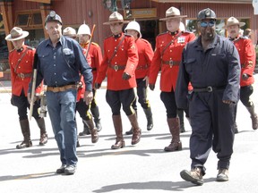 Former Canmore miners Ed Latvala, centre, and Rob Buschulak lead a contingent of Mounties down Main Street at the head of the annual Canmore Miners' Day parade on Saturday, July 13, 2013. Russ Ullyot/Crag & Canyon/QMI Agency