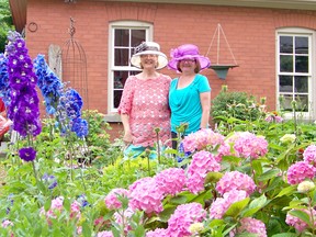 Proclaiming themselves "Horti's in Hats", Suzanne Blocklebank, right, from Shakespeare, ON., and Lorralee Smith, left, of Straford, ON., look right at home and ready for "Rain or Shine" in this colourful perennial garden during the Kincardine Horticultural Society's "Through the Garden Gate" tour in Kincardine on July 7, 2013. (JACQUIE TAYLOR/KINCARDINE NEWS FREELANCE)