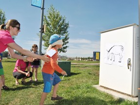 Sizzlin’ Summer Extravaganza leader Julie Chichak leads Kahlen Johnson, 5, to the game surface for a pin the tail on the donkey game. It turns out the blind fold was a little too see through and Johnson was able to find the right spot with little trouble.
Barry Kerton | Whitecourt Star