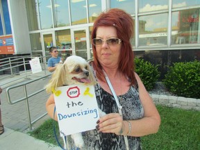 Suzanne Fitzgerald holds her dog, Tucker, during an information picket members of the Canadian Union of Postal Workers held Thursday afternoon at the post office in downtown Sarnia. They say Canada Post is planning changes at the post office customer counter that will reduce jobs, and service. Sarnia, Ont., July 18, 2013. PAUL MORDEN/THE OBSERVER/QMI AGENCY