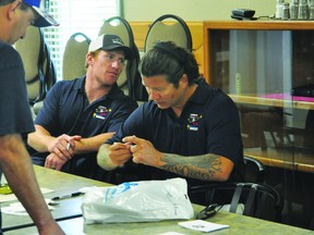 New York Ranger forward and Portage la Prairie product Arron Asham signs autographs while Colorado Avalanche forward Cody McLeod looks on during Asham's Chance 2 Play Golf Tournament July 19. (Kevin Hirschfield/THE GRAPHIC/QMI AGENCY).