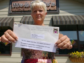 Port Stanley restaurateur Suzanne Van Bommel holds an anonymous letter which says her support for PrideFest this weekend in the community could cost her business. Eric Bunnell/QMI Agency/Times-Journal