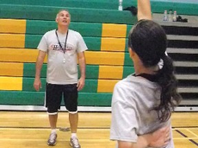 Kristeen Lynch executes a free-throw drill under the watchful eye of head instructor David DeAveiro during his basketball camp at Holy Trinity.