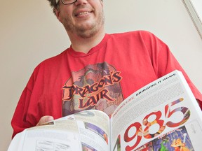Syd Bolton shows a copy of his new book, Collecting For Dragon's Lair and Space Ace, the revolutionary video games that debuted in 1985. (Brian Thompson, The Expositor)