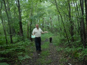Jeff Avery and his dog Bear stand in the middle of a 4-wheeler trail on the wetlands property which he hopes will become Pointe Estates subdivision.