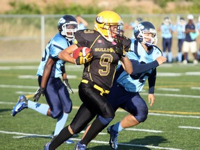 North Bay Jr. Varsity Bulldogs kick returner Josh Prior blasts past a pair of Oshawa Hawkeyes Saturday at Steve Omischl Sports Field Complex. Prior scored his first-ever OVFL touchdown on a 85-yard kickoff return.