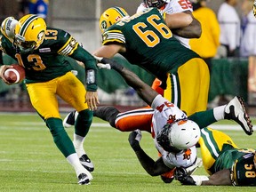 Edmonton Eskimos Mike Reilly #13 pulls away from BC Lions Khreem Smith #94 as Matthew O'Donnell #66 runs interference on Lions Julius Williams #55 as Eskimo Cliff Louis #58 lays on the ground during second half CFL action at Commonwealth Stadium in Edmonton, Alta. on  Saturday, July 13, 2013. The Eskimos lost 17-3. Amber Bracken/Edmonton Sun/QMI Agency