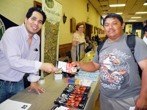 A health fair for seasonal workers was held at the Simcoe Legion Friday evening. Alexes A. Barillas Zuniga, one of the event's organizers and a national representative from the  United Food and Commercial Workers Union hands a pamphlet to Juan Alboroz, a seasonal worker from Mexico.