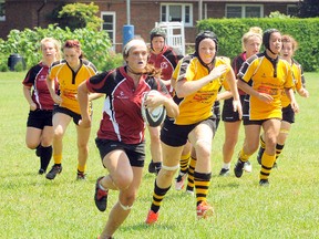 Raquel Rose of the Norfolk Harvesters hustles with the ball while being chased by members of the Hamilton Hornets during a women's rugby game Saturday. The Harvesters fell to the Hornets 38-34.