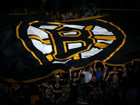 Boston Bruins fans hold a giant flag with the Boston Logo on it at TD Garden on June 24, 2013 in Boston, Mass.  (Elsa/Getty Images/AFP)