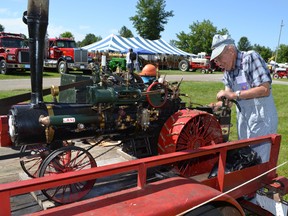 Stuart McKinnon adds wood chips to a model steam engine at Athens' 34th annual Farmersville Exhibition on July 21. (LESLIE WALKER/The Recorder and Times)