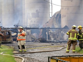 Firefighters from around south Oxford county survey the damage to a cattle barn after an early morning fire destroyed the structure at a farm on Clarke Road near Beachville on Monday July 22, 2013.  Over 100 cows were killed in the blaze which was discovered by a passing motorist on nearby Highway 401 just after 2 a.m.  The residents of the farmhouse were evacuated safely.(CRAIG GLOVER, The London Free Press)