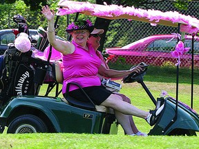 Kathy Wright, dressed in the official pink of the Rose of Hope Golf tournament that is held annually at the Cataraqui Golf & Country Club, waves from her golf cart during the event.     (SUPPLIED PHOTO)