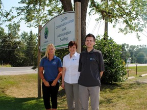 Quinte Conservation summer students Christine Jennings and Mark Goguen stand on either side of communications specialist, Jennifer May Anderson and soak up the hot sun.