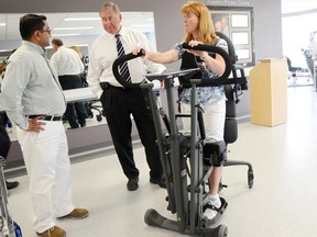 Frances Schmidt, restorative aid at Hastings Manor, demonstrates how the manor's new EasyStand Evolve equipment is used during a presentation Monday. Also shown is physiotherapist Rajesh Kini and Prince Edward-Hastings MP Daryl Kramp.