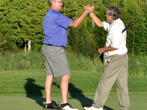 David MacInnes, left, and Bob Chasse celebrate on No. 18 after winning the 23rd annual Molson Lever/Sullivan Classic Golf Tournament held this past weekend at Hollinger Golf Club. It was Chasse’s first time winning and MacInnes’ second time. The pair set a new tournament record, shooting a 58 in the championship round.