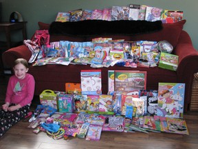 8-year-old heart transplant recipient Ryley Mitchell sits beside all of the presents she donated to SickKids Hospital's Treasure Box program for children who have undergone traumatic procedures.  (Submitted photo)