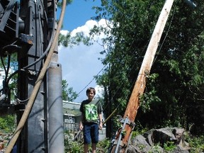 Benjamin Munro stands next to where a hydro pole had fallen over during Friday's storm and where a new one was going to be drilled to rewire the hydro lines on Mill Road.