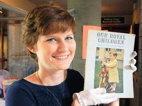 Katie McNamara, an employee of the Eva Brook Donly Museum, holds a book from the 1950s about the Royal family that is part of a display on the second floor of the Norfolk Street South museum. (DANIEL R. PEARCE Simcoe Reformer)