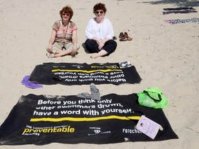 Cindy Kirkpatrick, left, of the Hastings and Prince Edward District Health Unite and Pamela Fuselli, vice-president of the organization Parachute, spread water safety messages at the Sandbanks Provincial Park in Prince Edward County Tuesday.