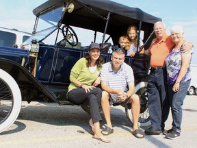 Michelle Byrne, John Potter, Garry Potter, Annette Potter and grandchildren Matthew and Victoria Potter, stand beside their 1913 brass Ford Model T on Tuesday in the parking lot of the Quality Inn Hotel and Suites in Woodstock.  (CODI WILSON/Sentinel-Review)