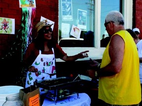 Lluvia Reza, an employee of the Auditorium Hotel, was all smiles as she doled out cups of coworker Alfredo Soles’ spicy chili during the 12th annual Chili Cook-off contest in downtown Nanton on Sunday Aug. 5. Soles’s chili was just one of 15 chilis which locals and visitors alike could sample and vote on during the annual cooking competition.