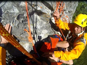 Parks Canada visitor safety specialist Brian Webster helps prepare an injured climber for a long line extraction from Tunnel Mountain's Gooseberry route on Sunday, July 21. The climber broke his back in a couple of places. AARON BEARDMORE/PARKS CANADA/QMI AGENCY