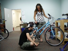 Jen Gibson gets a helping hand and some advice from Matt Zimmerman during the Canmore Community Cruisers Open House on Thursday, July 18, 2013 in the group's new facility inside the Old Canmore Library building in downtown Canmore. Russ Ullyot/ Crag & Canyon/ QMI Agency