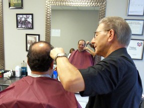 Carmine Perrotta cuts the hair of North Bay Coun. Dave Mendicino, his first customer, during the opening of the 73-year-old’s new business on Trout Lake Road in the Freschco plaza. Mendicino is the son of the barber who first hired Perrotta when he came to North Bay in 1963.