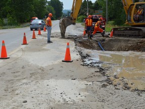 Crews work at the scene of a watermain break at the corner of Helen St. and Sykes St. on Monday afternoon. (Rob Gowan The Sun Times)