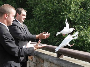 Shelby Ingold and Jame Rutherford of James A. Rutherford Funeral Home in Stratford release a pair of white doves by the Festival bridge Wednesday. MIKE BEITZ The Beacon Herald