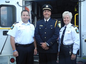 Aaron Archibald, deputy chief of the city's EMS operations (left), Dennis Melanson and Jennifer Amyotte, chief of community health and professional standards, attend a funding announcement Wednesday at EMS's garage in Azilda.