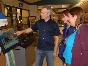 Broca Media programmer Collin Waldroff (left) goes through some of the features of the new information kiosk with Broca Media owner Karna Germshied (middle) and the Grande Prairie Reginal Tourism Association executive director Ainsley Lamontagne on Tuesday, at the Grande Prairie Airport to see if everything, WiFi and all the information settings on the kiosk are a go before the official unveiling of the kiosk Wednesday. The new kiosk will function similarly to an iPad, with different icons that will allow tourists to map out directions to different local events, hotels and attractions. (Jocelyn Turner/Daily Herald-Tribune)