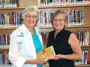 Author and Coney Island summer resident Lyn Thompson (left) presents head librarian Cathy Peacock with her latest book ‘Bella: A Woman of Courage’ at the Kenora Public Library on Tuesday.
MARNEY BLUNT/Daily Miner and News