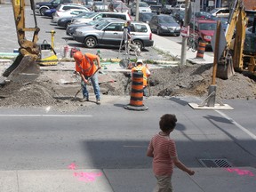 Construction workers install one of three speed humps on Brock Street on Monday.
Ian MacAlpine The Whig-Standard