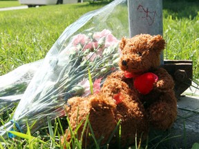 Two teddy bears and some flowers lie a house on Coleridge Park Drive where two young children were found dead in Winnipeg, Man. Wednesday July 24, 2013.BRIAN DONOGH/WINNIPEG SUN/QMI AGENCY