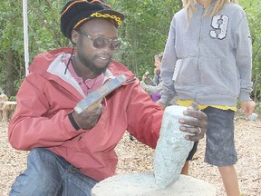 Isaac Scott, 8, from Hamilton, looks on as Chaka Chikodzi works on a piece of rock during a sculpting workshop, part of the Out of the City summer arts camp. The week-long camp exposes participants, some of them from inner cities, to various aspects of art.
Michael Lea The Whig-Standard