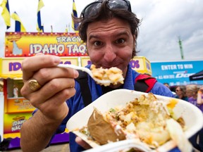 Intrepid Edmonton Sun scribe Dave Lazzarino tries an Idaho potato at K-Days in Edmonton, Alta., on Wednesday, July 24, 2013. Codie McLachlan/Edmonton Sun/QMI Agency