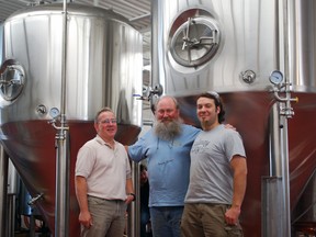 Railway City Brewing Company vice-president Matt Janes, left, stands with brewer Tom Anguish and head brewer Zach Trynda in front of a set of new equipment at the company's brewery on Edward St. in St. Thomas. The new equipment will give Railway City five times as much brewing capacity and will help meet growing demand.