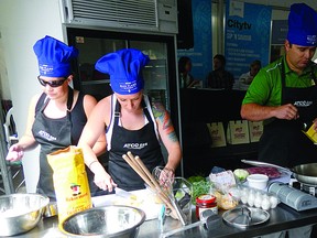 Jocelyn Bird (left), Suzanne Bird and Russell Bird cook up a storm at the inaugural Mystery Box Competition at the Taste of Edmonton. Team Bird took home the first place prize. Photo Supplied