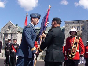 The Royal Military College of Canada's new commandant Brig.-Gen. Al Meinzinger, left, accept the college's colours from outgoing commandant Maj.-Gen. Eric Tremblay during Thursday's change of command ceremony.                 
Elliot Ferguson The Whig-Standard