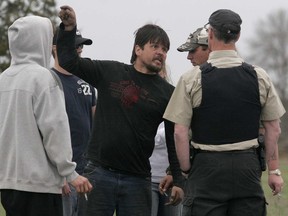 Protester and native spokesman Dan Doreen, centre, shouts at Ontario Provincial Police officer Steve Flynn (wearing vest) near a disputed quarry just north of Deseronto, Ont. Friday, April 25, 2008. A heated discussion at an Ontario Provincial Police roadblock near the quarry escalated into a scuffle and several arrests, including that of Doreen, were followed by an armed standoff when police spotted what they believed to be a "long gun" aimed at them. 

Luke Hendry/Intelligencer file photo